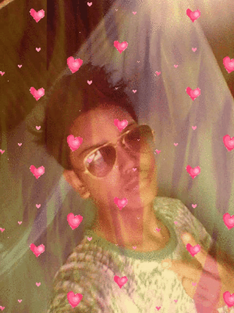 a woman wearing sunglasses is surrounded by hearts
