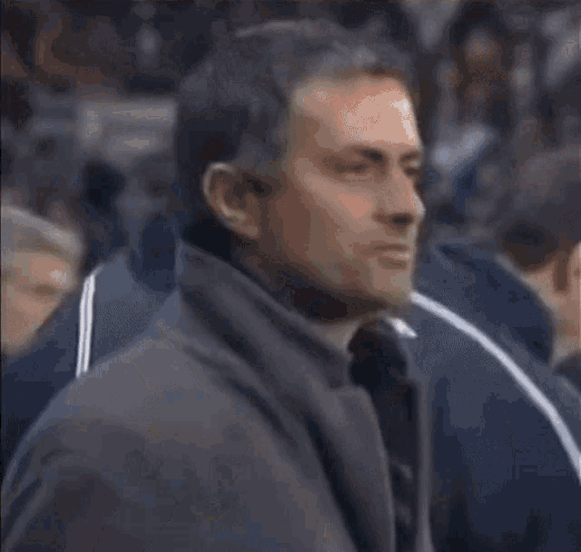 a man on a soccer field wearing a jacket that says emirates on the back