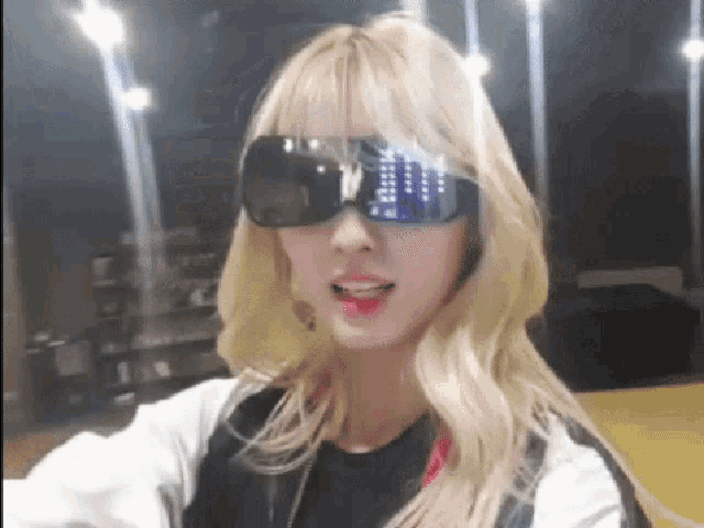 a woman wearing sunglasses and a white jacket is smiling