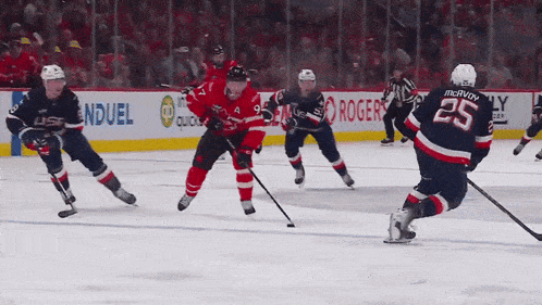 a hockey game is being played in front of an ad for rogers