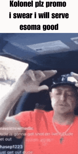 a man in a red shirt is sitting in a car and making a swear