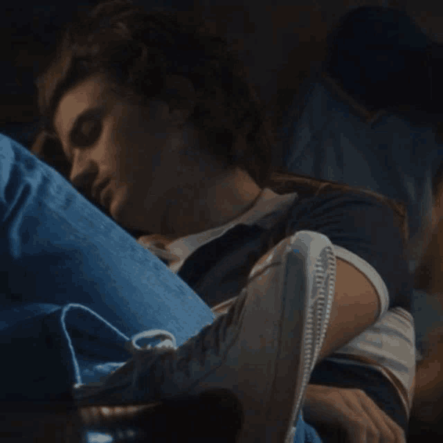 a young man is laying on his stomach with his feet up