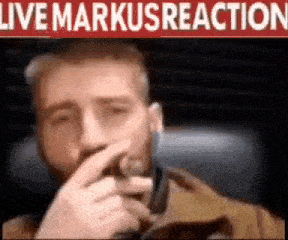 a man with a beard is holding a microphone in his hand and covering his mouth .