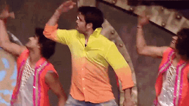 a man in a yellow shirt is dancing with a group of people