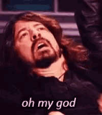 a man with a beard is laying down and saying oh my god .