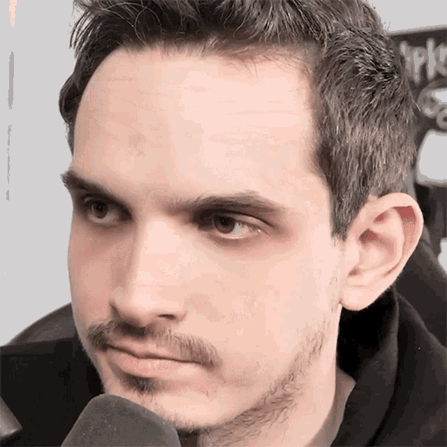 a close up of a man 's face with a black shirt on