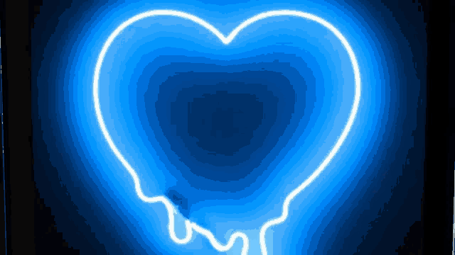 a blue neon sign in the shape of a heart is glowing on a black background .