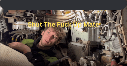 a man is laying in a machine with the words shut the fuck up mate