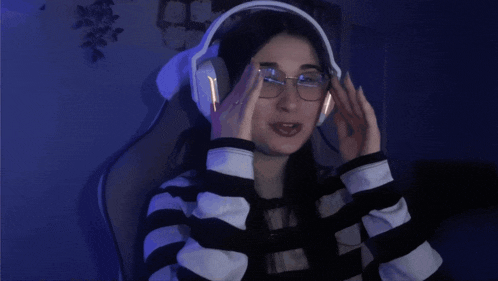a woman wearing headphones giving a thumbs up