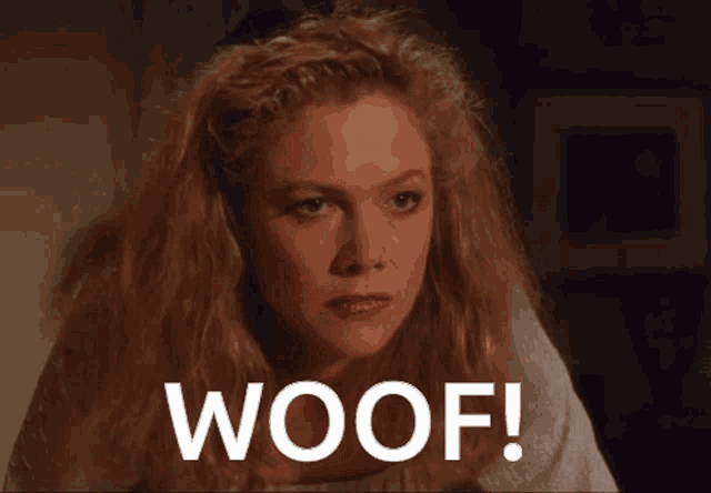 a woman with blonde hair says woof in a dark room