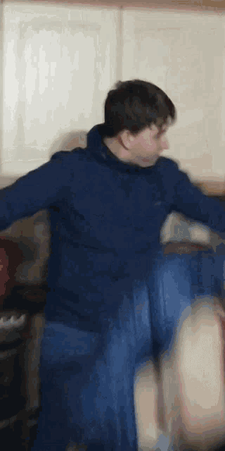 a blurry picture of a man in a blue sweatshirt and blue jeans