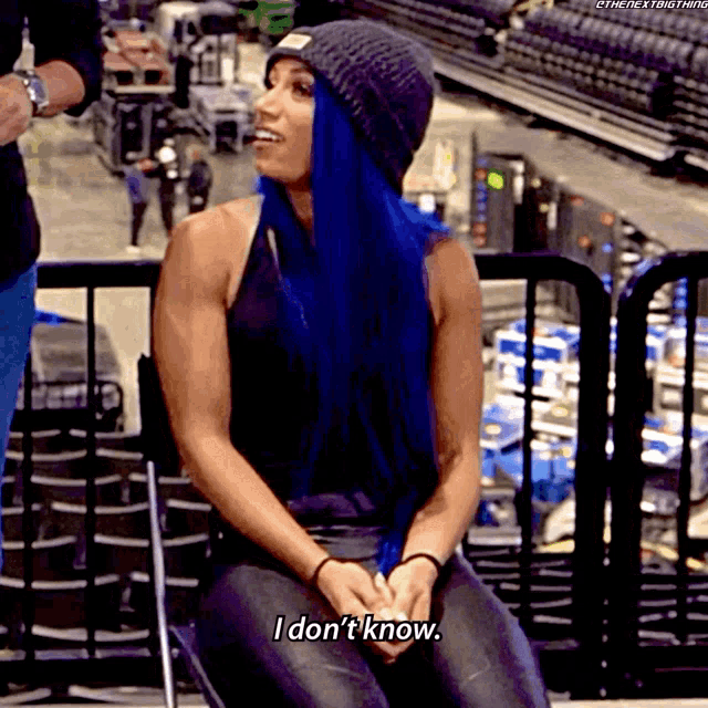 a woman with blue hair is sitting on a chair and says i don 't know