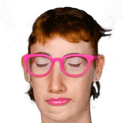 a woman wearing pink glasses is making a funny face with her eyes closed
