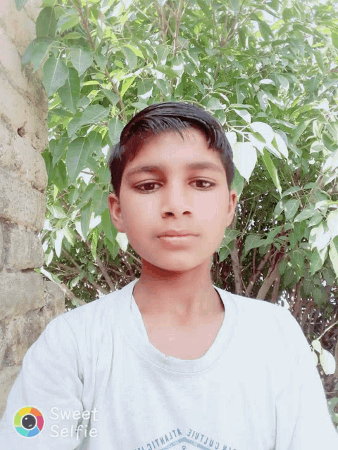 a young boy taking a selfie with the words sweet selfie on the bottom right