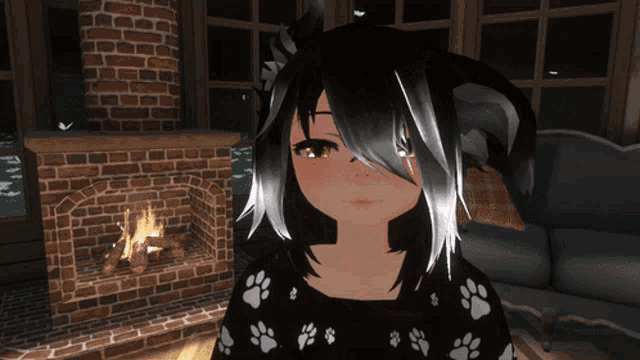a girl in a paw print sweater is standing in front of a fireplace
