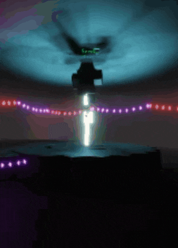 a helicopter is flying over a dark room with purple lights