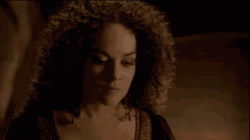 a close up of a woman with curly hair making a funny face .