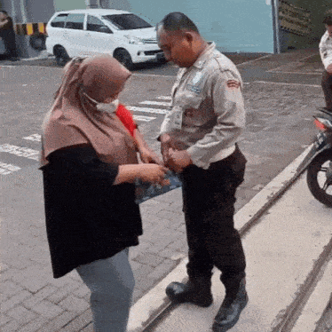 a man in a police uniform talks to a woman in a mask