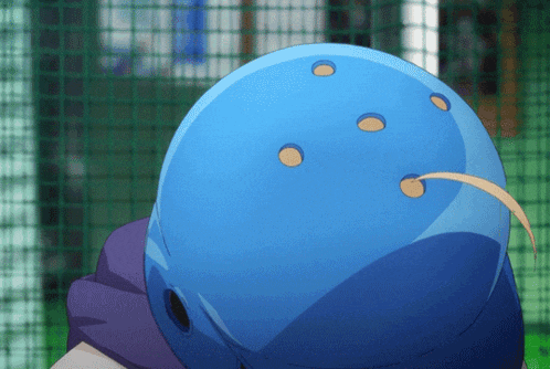 a person wearing a blue helmet with holes in it is standing in front of a fence