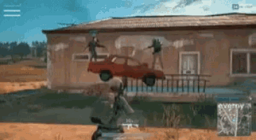 a red car is sitting on top of a fence in front of a building in a video game .
