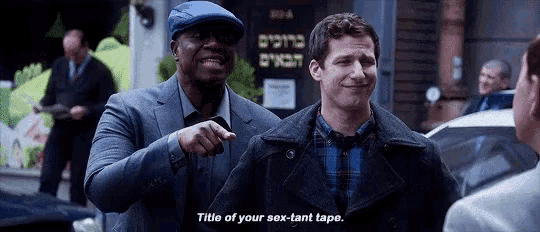 two men are standing next to each other and one of them is pointing at the other and saying title of your sex-tant tape
