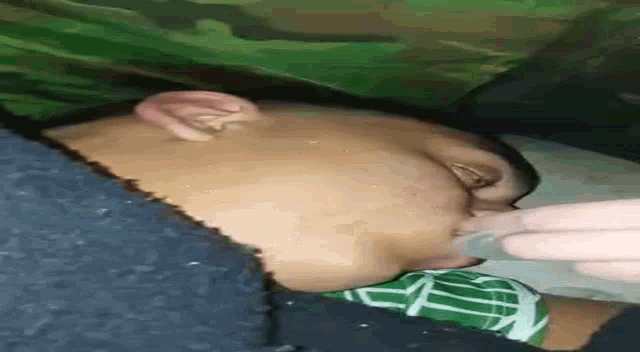 a close up of a person 's face with a bottle in it .