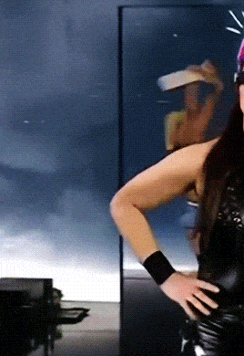 a woman wearing a cowboy hat is standing with her hand on her hip