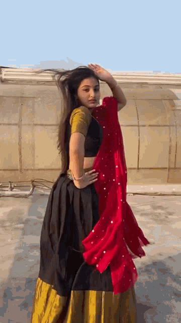 a woman in a black and gold dress is dancing on the roof .