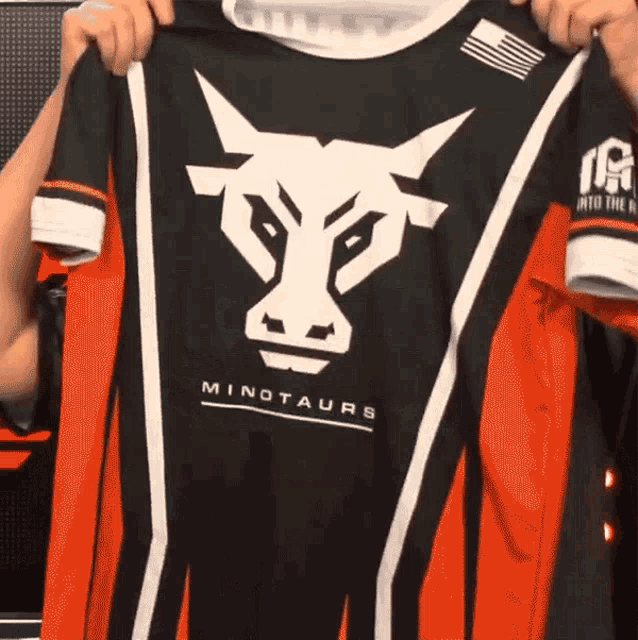 a person is holding up a shirt that says minotaurs on it