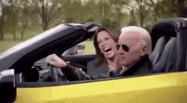 a man and a woman are laughing in a yellow convertible car .