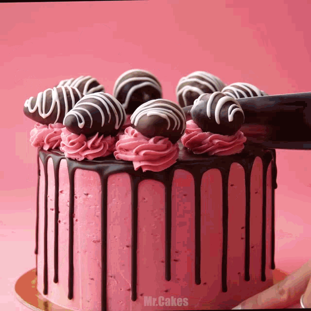 a cake with pink frosting and chocolate covered strawberries has the word mr.cakes on the bottom