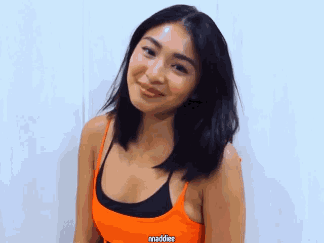 a woman wearing an orange top with maddiee written on it