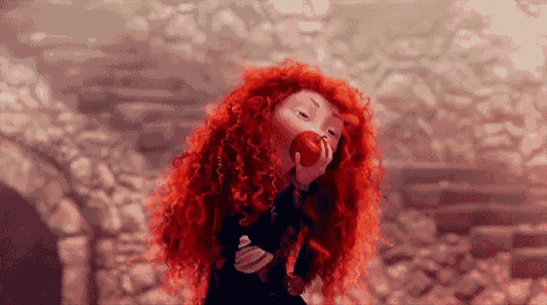 a cartoon character with red hair is eating an apple from a tree .