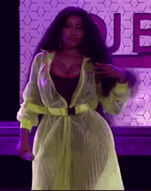 a woman with long hair is standing on a stage holding a microphone .