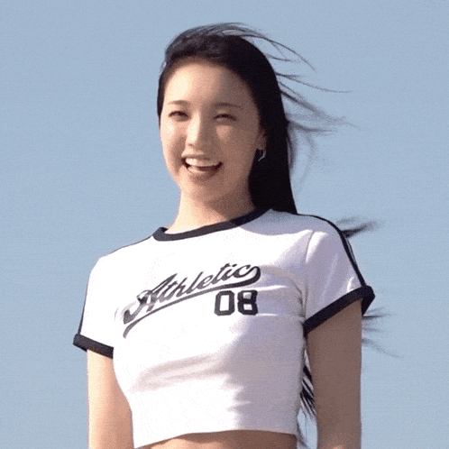 a woman wearing an athletic 08 t-shirt is giving a thumbs up