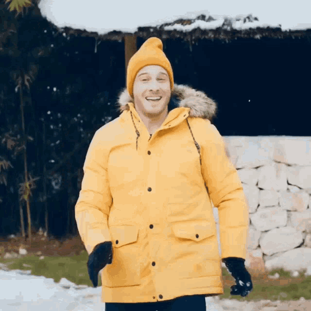 a man wearing a yellow jacket and a yellow hat is smiling