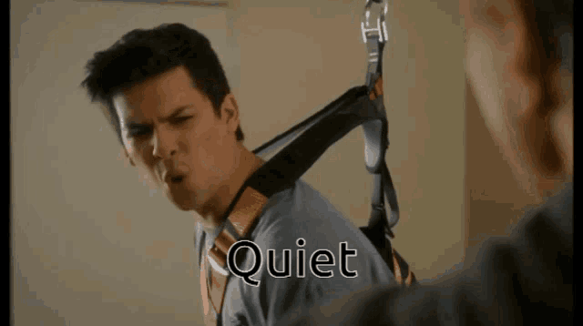 a man is wearing a harness with the word quiet written on it