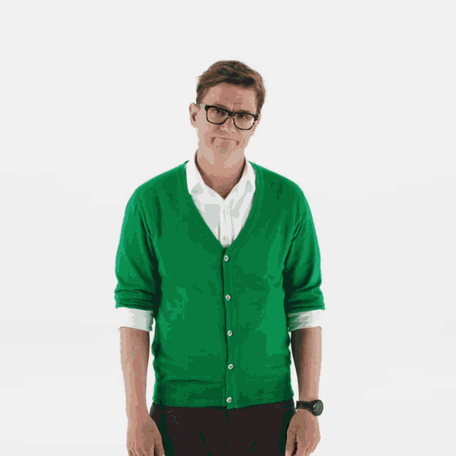 a man wearing glasses and a green cardigan