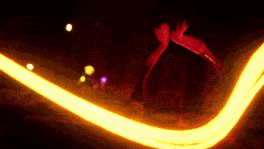 a person is standing in a dark room holding a yellow light