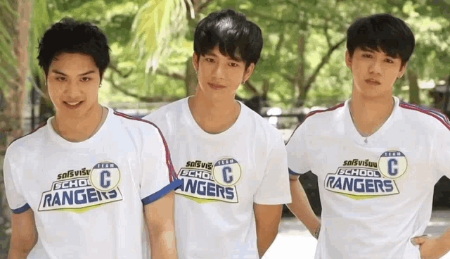 three young men wearing white t-shirts that say school rangers