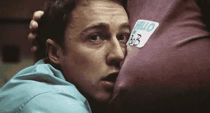 a man is hugging a person with a name tag that says hello bb on it .