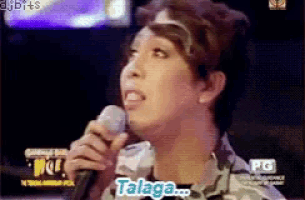 a woman singing into a microphone with the word talaga visible