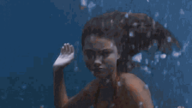 a woman is swimming in a body of water .