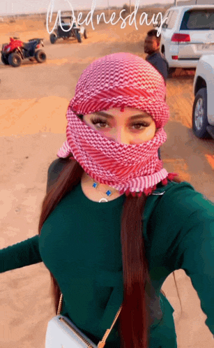 a woman wearing a head scarf is taking a selfie on wednesday 's