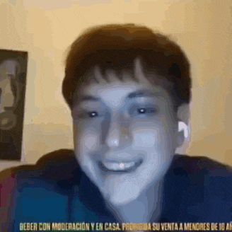 a young man wearing ear buds is smiling in a video call .