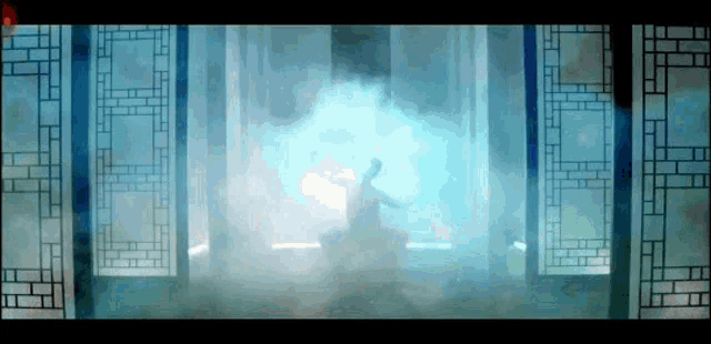 a silhouette of a person dancing in a room with a blue light behind them