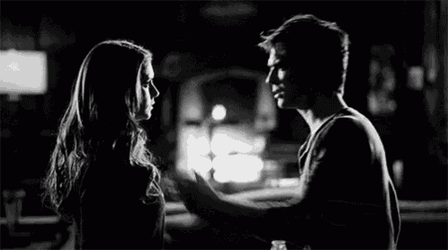 a man and a woman are standing next to each other and touching each other 's faces .