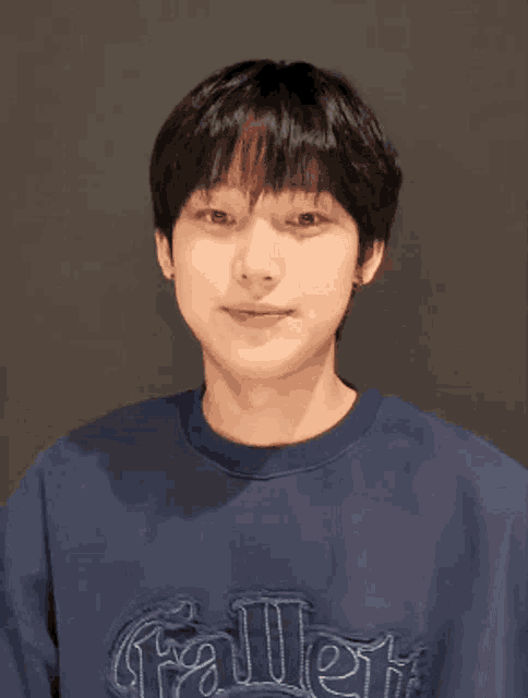 a man wearing a blue shirt that says fallen on it