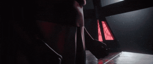 a person 's hands are reaching out in the dark