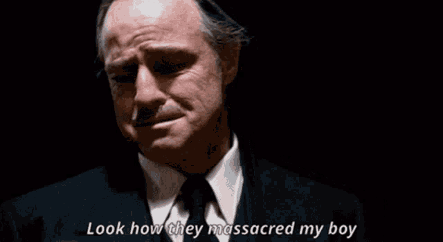 a man in a suit and tie is talking about how they massacred his boy